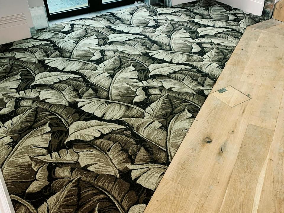 Bold leaf-pattern carpet next to oak flooring